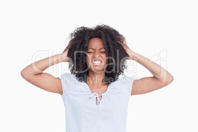 Young woman showing her anger by holding her head