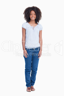 Relaxed young woman standing upright with arms by side