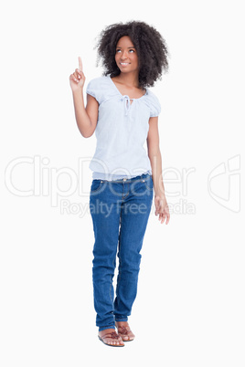 Young woman raising her finger in the air while looking up