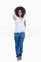 Serious woman standing upright with her thumbs up and a hand on