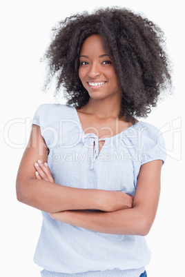 Smiling young curly woman crossing her arms