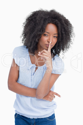 Young serious woman crossing arms while placing her finger on he