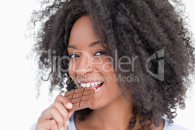 Young woman looking at the camera while eating chocolate