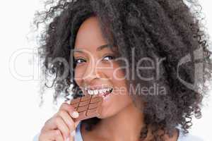 Young woman looking at the camera while eating chocolate