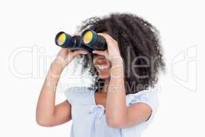 Young woman looking on the side through binoculars