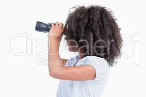 Side view of a young woman looking through binoculars