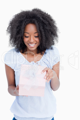 Happy young woman opening her birthday gift