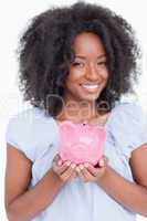 Young smiling woman holding a piggy bank