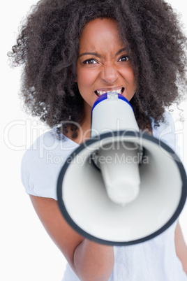 Young woman speaking loud into a megaphone