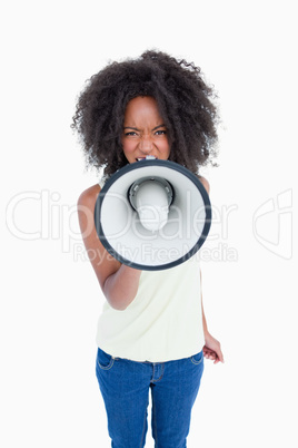 Angry young woman talking into a megaphone