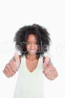 Thumbs up showed by a young woman with curly hair