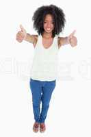 Young smiling woman placing her thumbs up in satisfaction