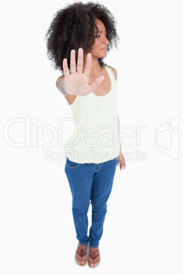 Young woman looking on the side while making the hand stop sign