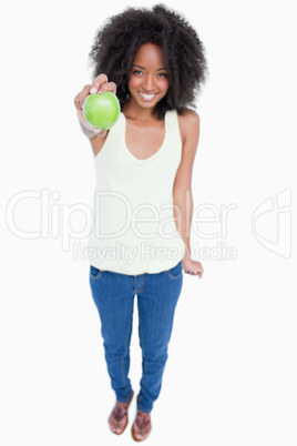 Relaxed young woman holding a green apple in front of her