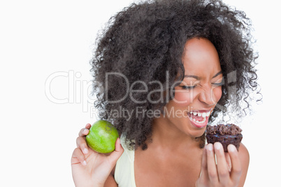 Young woman on the point to eat a chocolate muffin