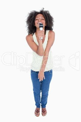 Young woman singing with a cordless microphone