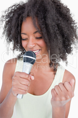 Young woman singing karaoke with a microphone