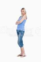 Relaxed young woman standing upright with arms crossed