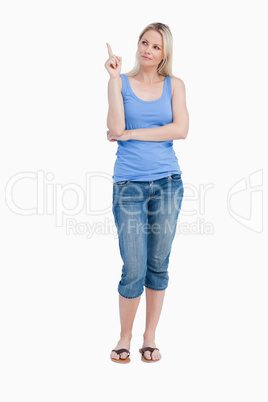 Blonde woman raising her finger while crossing arms