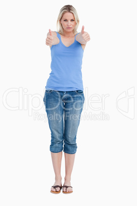 Serious blonde woman showing her thumbs up