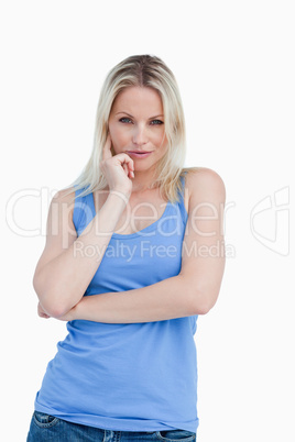 Thoughtful blonde woman placing a finger on her cheek