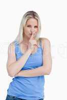 Blonde woman telling to be quiet with her arms crossed