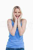 Happy blonde woman showing her surprise by placing her hands on
