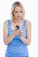Serious woman looking at her mobile phone while concentrating