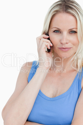 Blonde woman looking at the camera while talking on the phone
