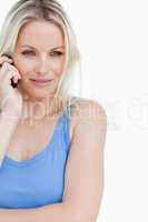 Serious blonde woman standing up while calling