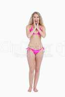 Surprised blonde woman wearing swimsuit while putting her hands