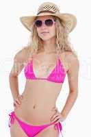 Attractive blonde teenager wearing a swimsuit with a hat and sun