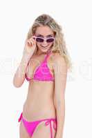 Smiling teenager in beachwear looking over her sunglasses
