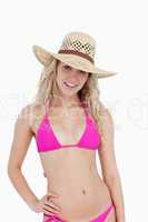 Smiling teenager wearing a pink swimsuit and a hat