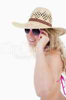 Smiling teenage putting on her sunglasses