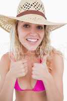 Smiling young attractive woman putting her two thumbs up