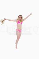 Smiling teenager jumping while opening her arms