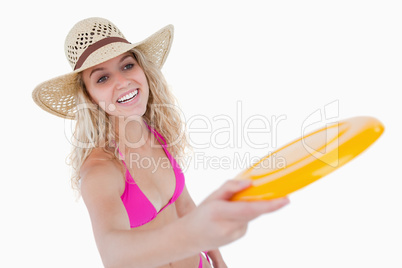 Smiling teenager in beachwear playing frisbee