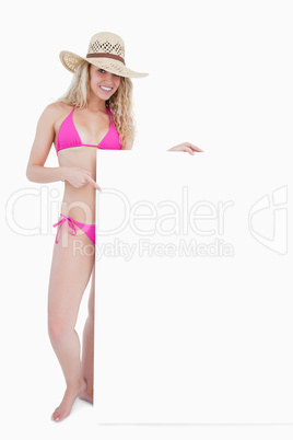 Smiling teenager in beachwear holding a blank poster