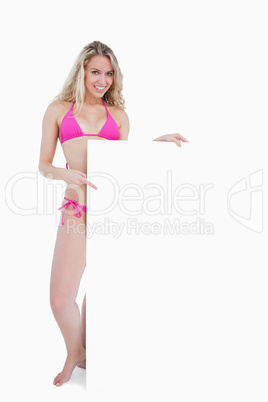 Young attractive woman smiling while holding a blank poster
