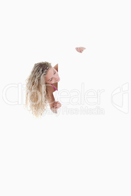 Smiling woman looking on the side while holding a blank poster