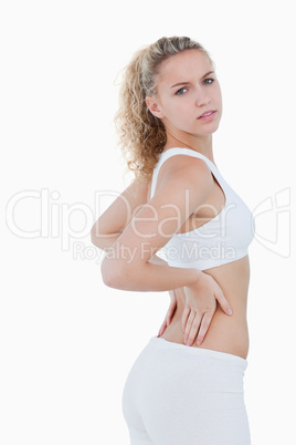 Young attractive woman touching her back