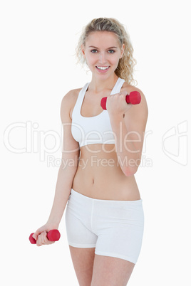 Smiling teenager looking at the camera while lifting weights