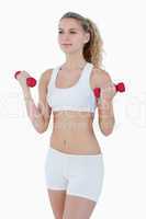 Concentrated attractive teenager lifting red weights
