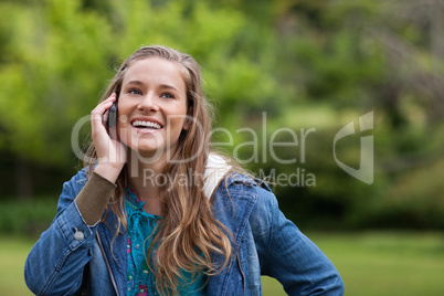 Teenage girl using her mobile phone while showing a great smile