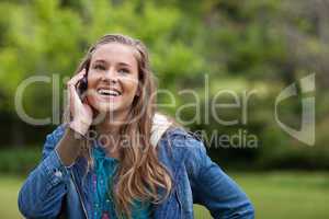 Teenage girl using her mobile phone while showing a great smile