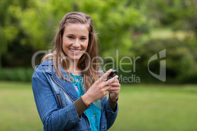 Teenage girl sending a text with her mobile phone