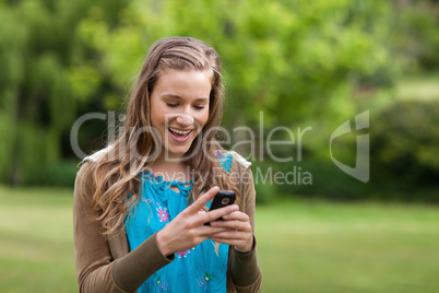 Happy teenage girl receiving a text on her mobile phone