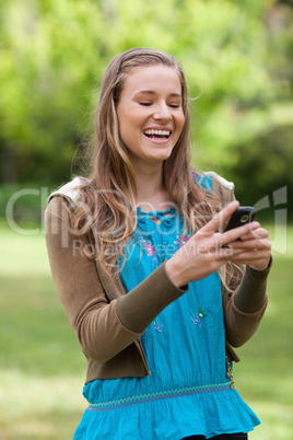 Teenage girl laughing while receiving a text on her cellphone