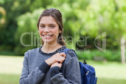 Young smiling girl standing upright in a park